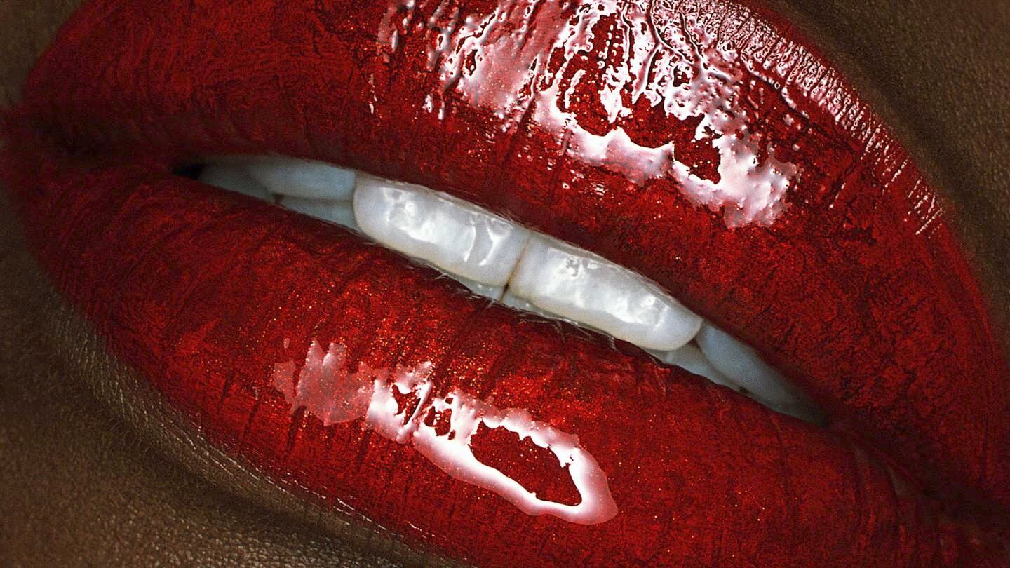 Woman wearing glossy red lipstick.