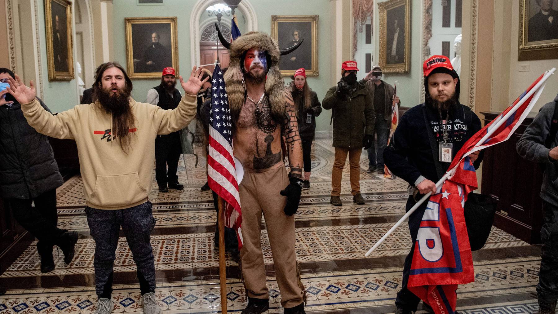 Supporters of US President Donald Trump, including Jake Angeli, a QAnon supporter known for his painted face and horned hat, enter the US Capitol. Getty Images.