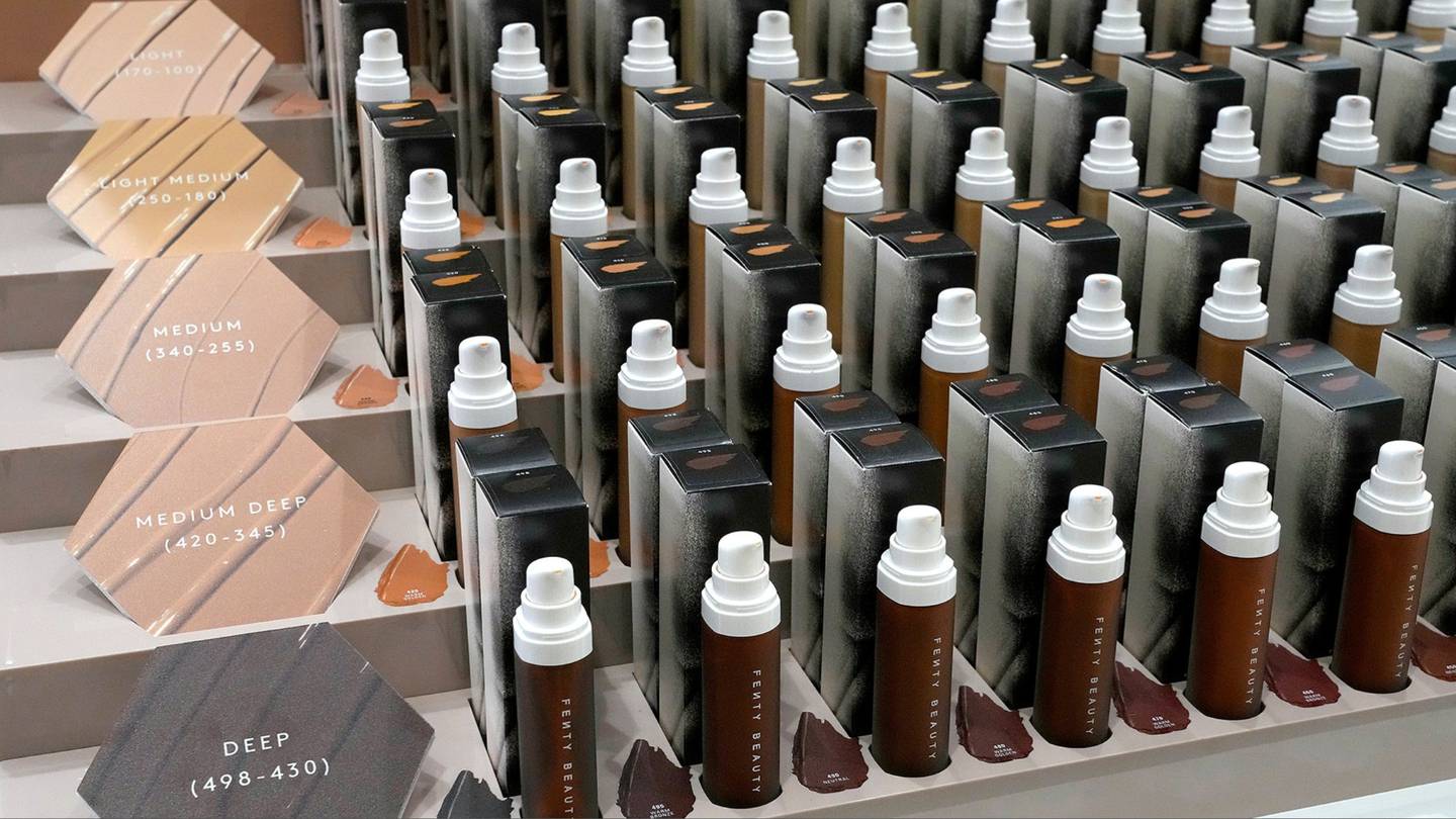 Rows and rows of Fenty Beauty foundation bottles of varying shades.