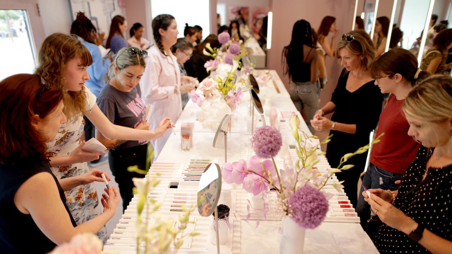 Customers try out products at a Glossier pop-up.