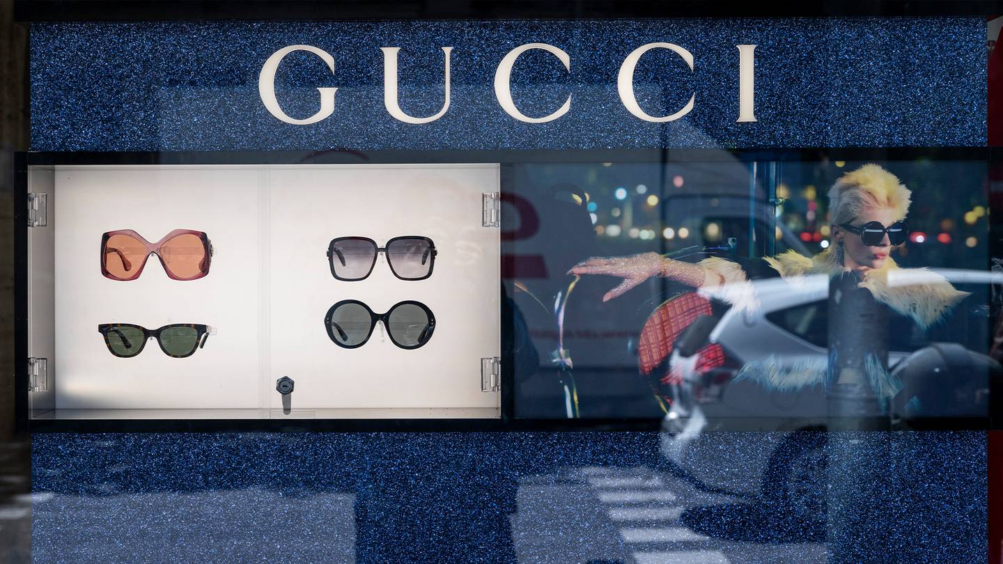A store window with four pairs of Gucci sunglasses. Three of the sunglasses have large round lens while one pair is a black cat eye shape.