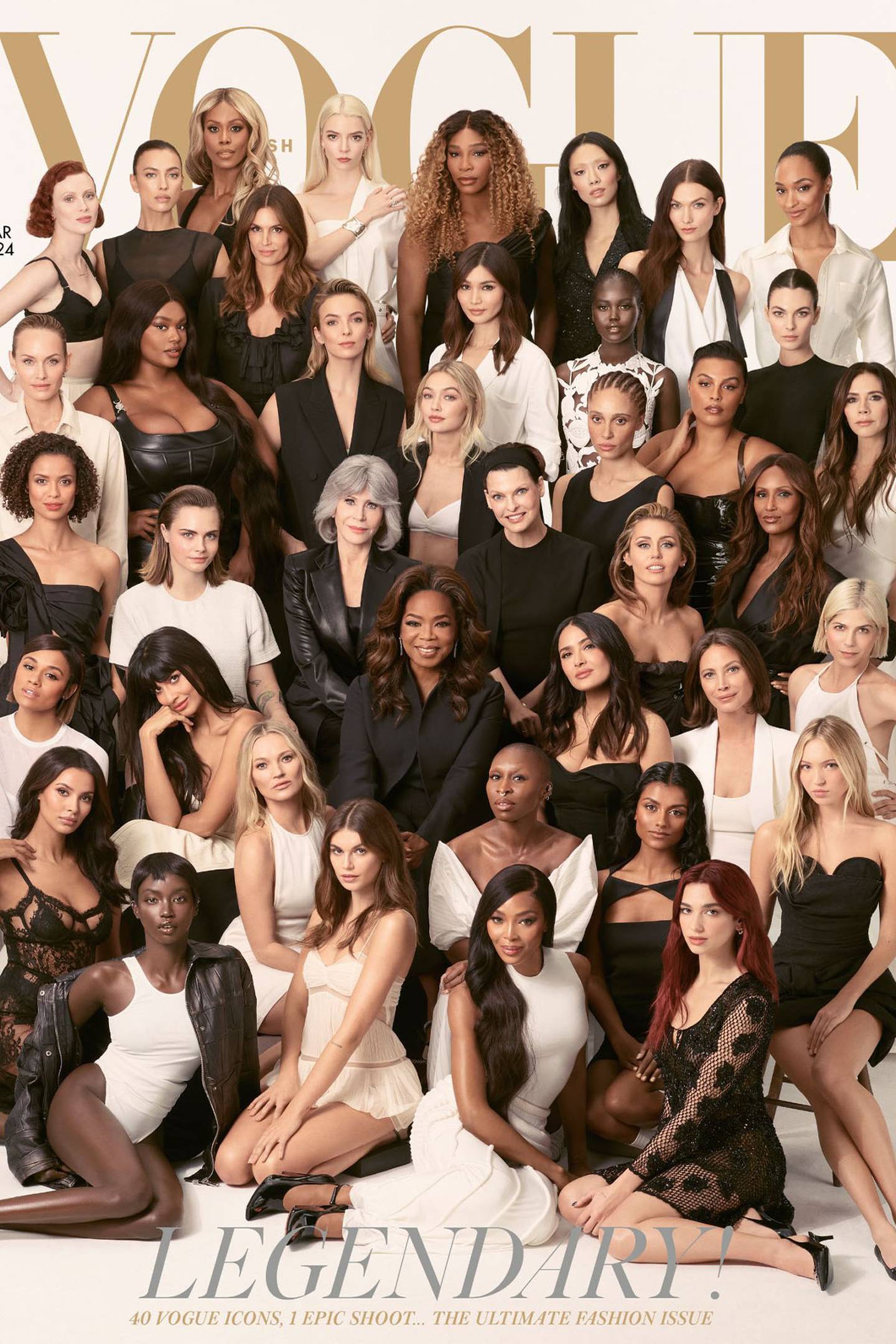 Image shows 40 women of varying ages and ethnicities gathered before a white studio backdrop. All are dressed in black, white or a combination of the two, and are looking into the camera. The four women at the front are sitting on the floor, and the rest are behind, arranged in rows that increase in height, so that all 40 are visible. Above their heads, the Vogue logo in gold letters. The cover line reads: “Legendary! 40 Vogue icons, one epic shoot... the ultimate fashion issue.”