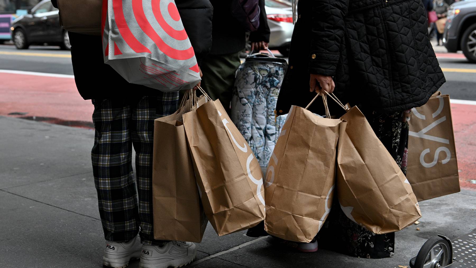 People carrying shopping bags stand outside Macy's on Black Friday in New York.