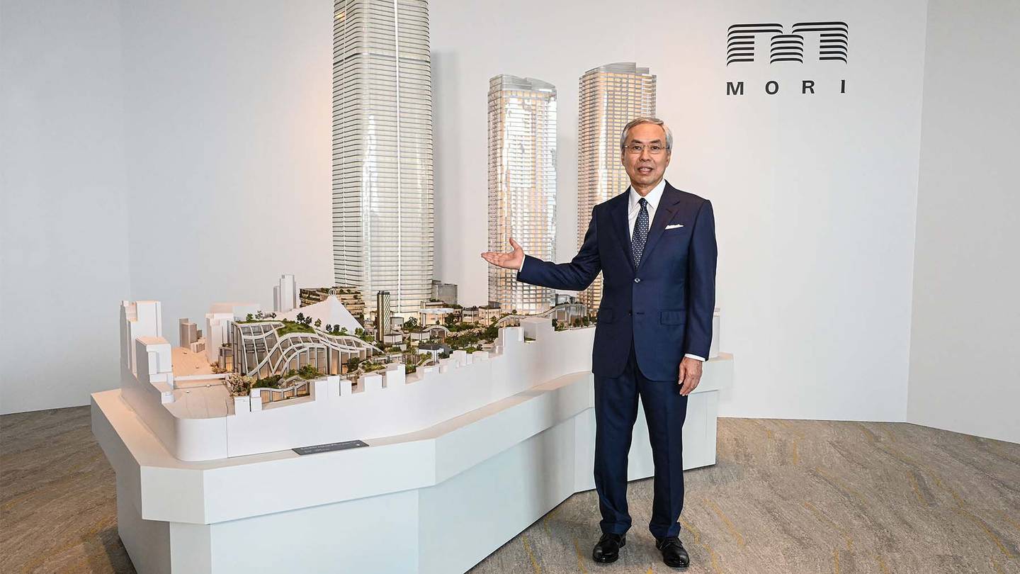 Shingo Tsuji, the head of Mori Building Co., Ltd., poses next to a model of "Azabudai Hills", the latest project by Japanese property developer Mori Building Co.