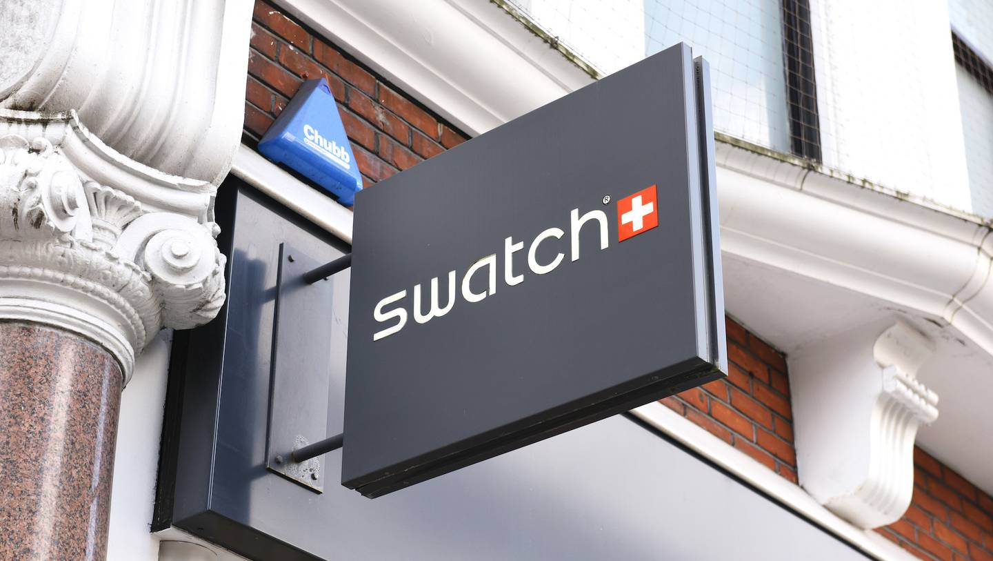 A Swatch sign hanging above a store.