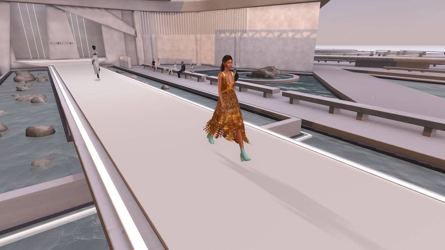 A virtual model walks a runway set over top of water with stones popping through.