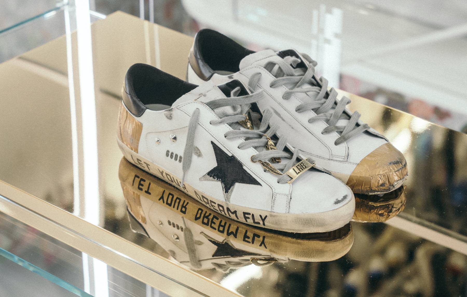 Distressed sneakers in a mirrored display at Golden Goose's new Milan flagship. Golden Goose.