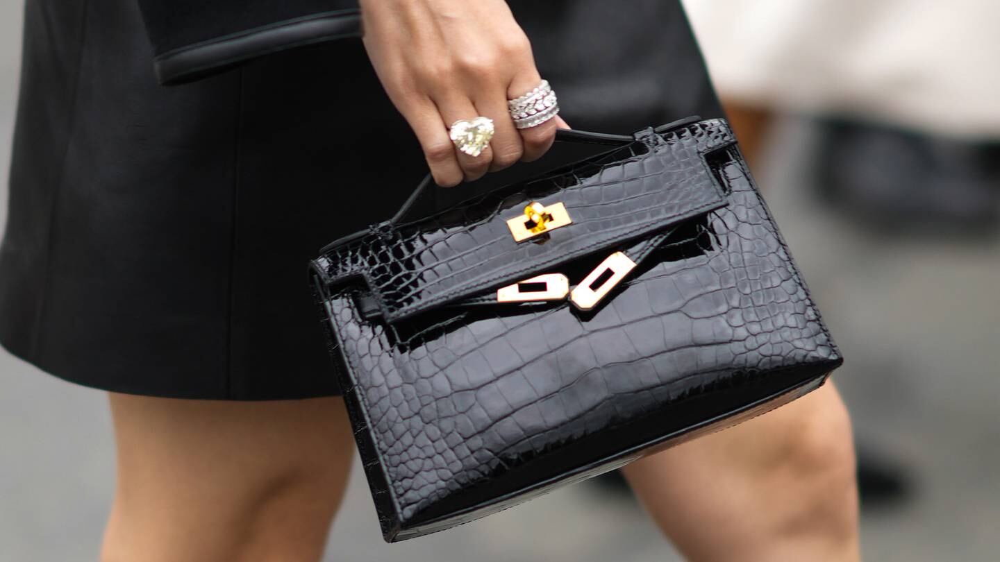 Guest arrives at Hermès' Paris Fashion Week show carrying an exotic leather handbag. The brand is working to adopt more more sustainable alternatives for the popular style.