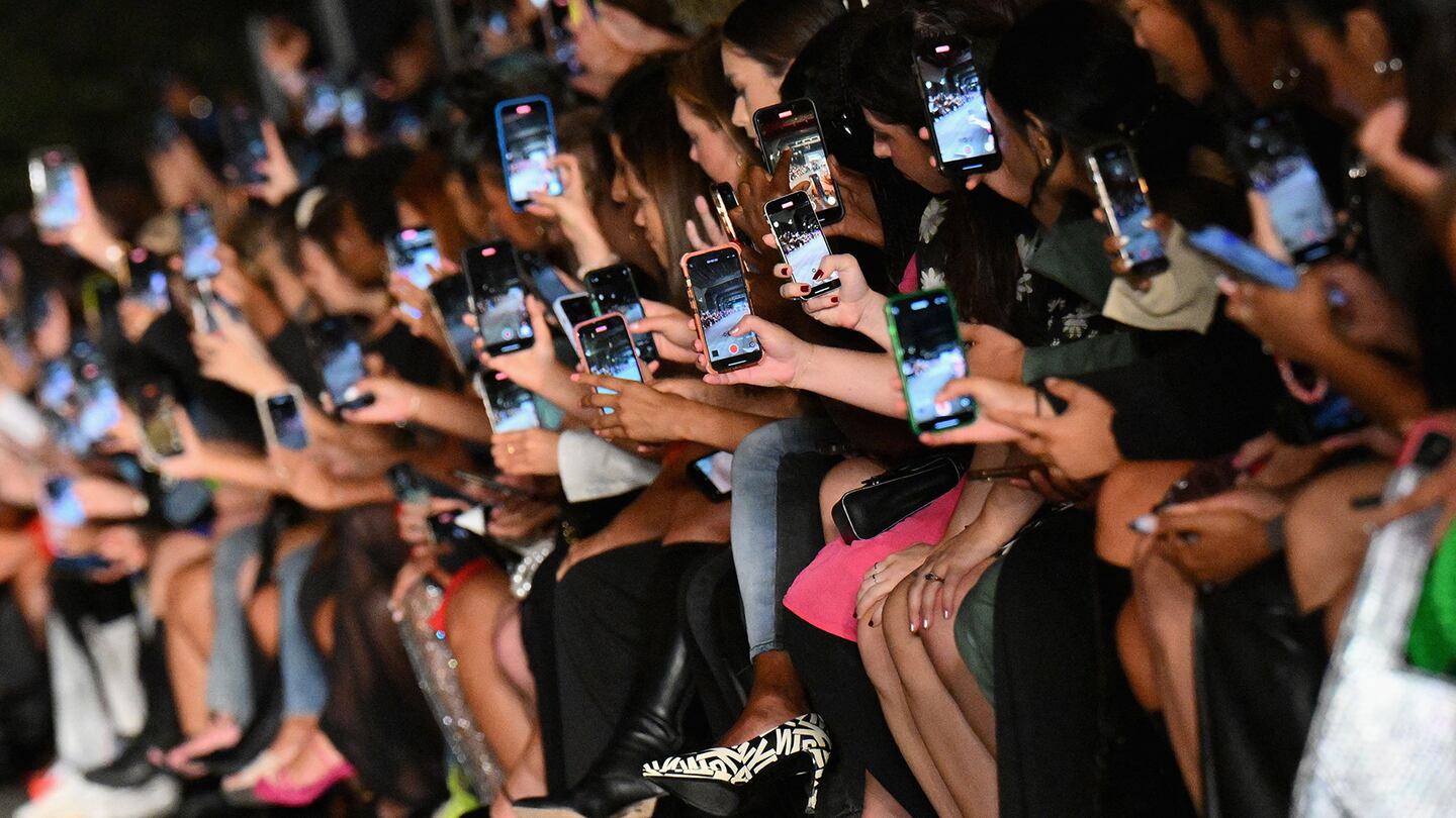 Guests hold their smartphones to record the Boohoo by Kourtney Kardashian show during New York Fashion Week