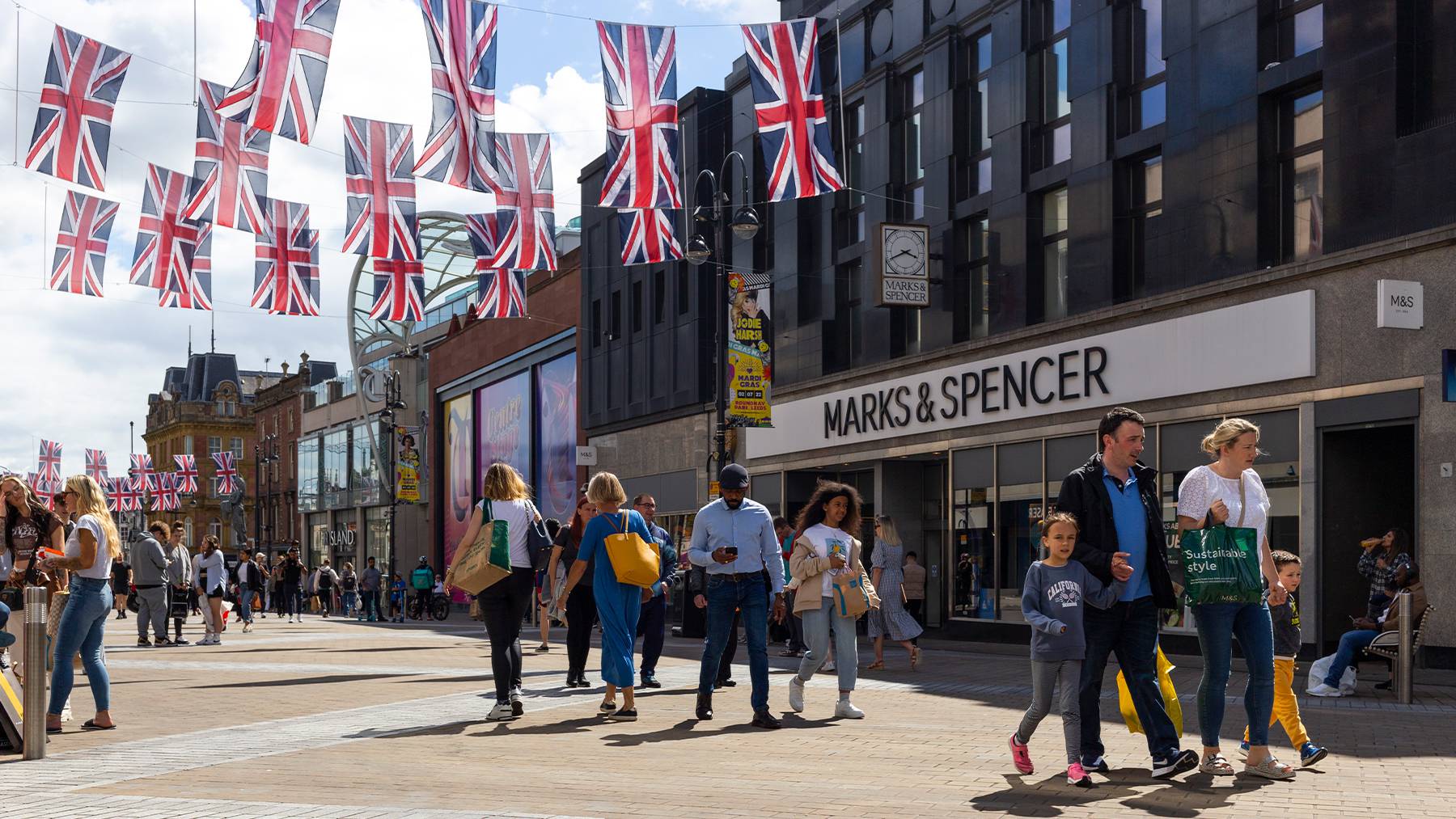 British highstreet with shoppers and union jack flags.