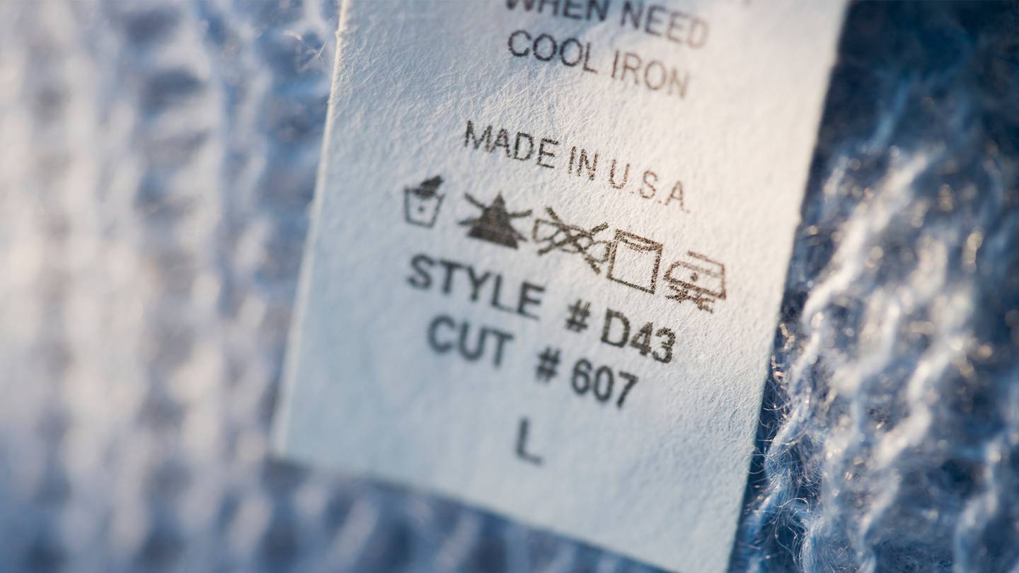 A clothing tag displays care instructions, several symbols and indicates that the garment was made in the USA.