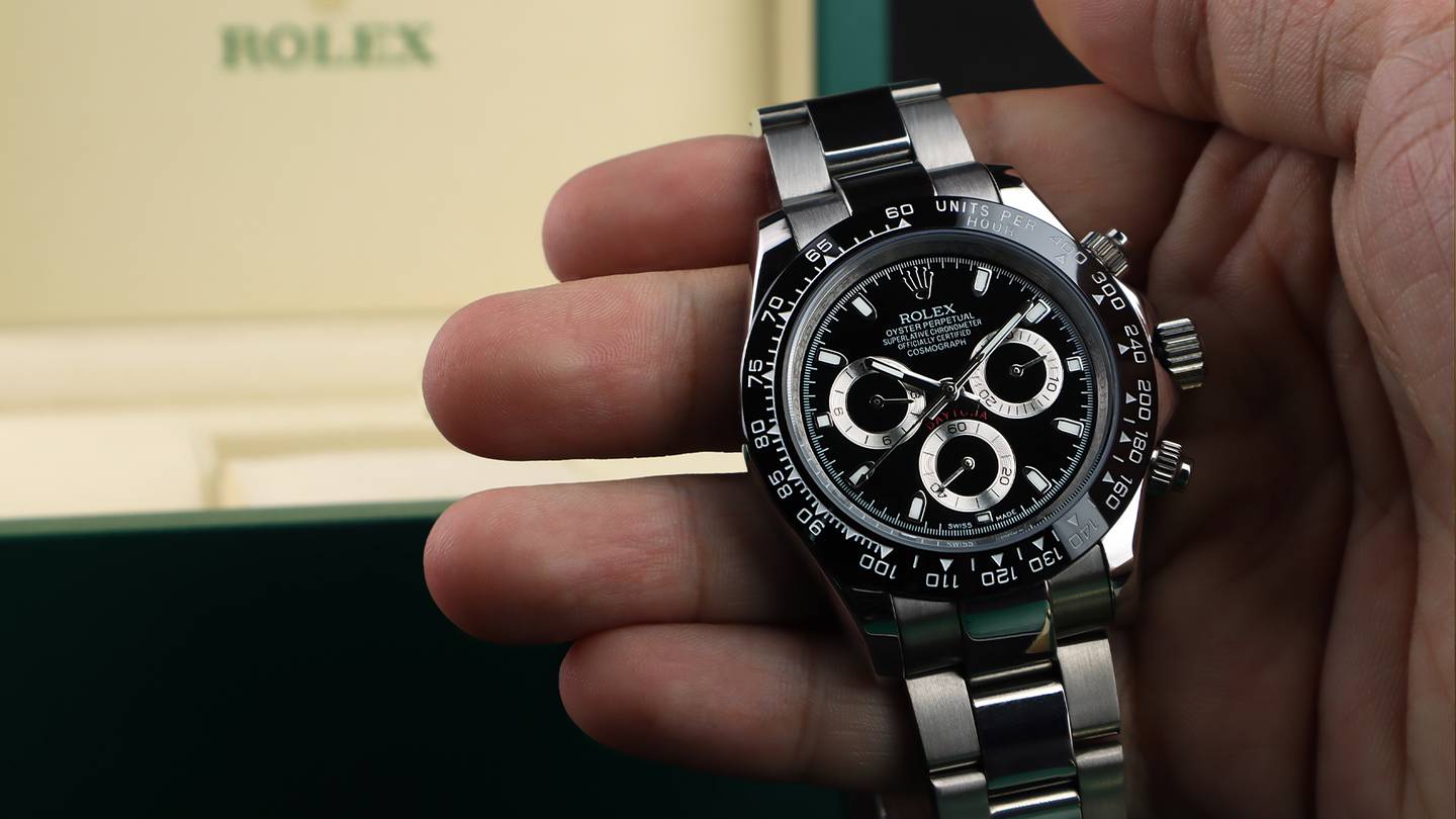 Rolex watch with grey and black detailing, with a Rolex box behind.