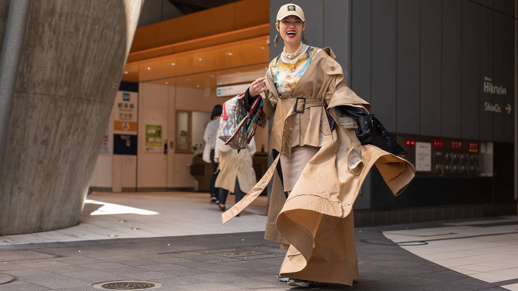 A guest is seen wearing trenchcoat and pearls attending Pillings in Shibuya at Rakuten Fashion Week Tokyo 2023 Autumn/Winter.