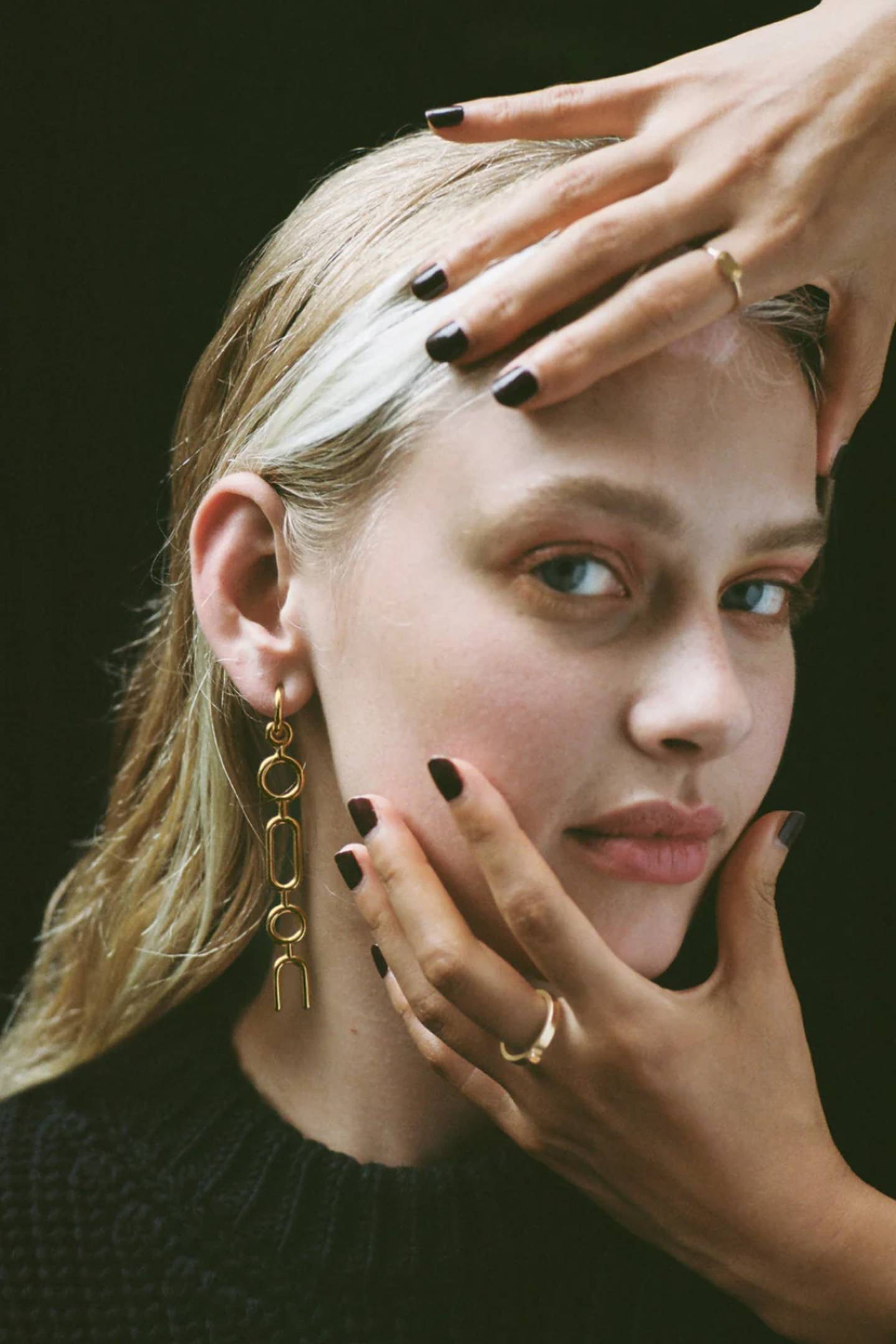 A model wears gold-plated hoops made from recycled materials.