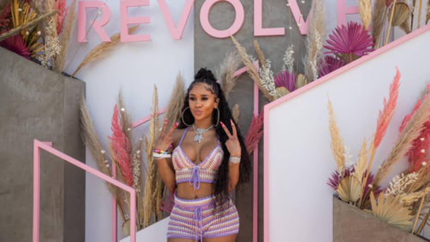 Rapper Saweetie standing in front of Revolve backdrop during Coachella in 2019.