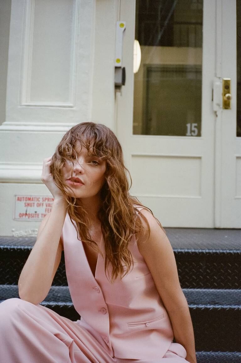 Model in pink suit sitting in Soho, New York.