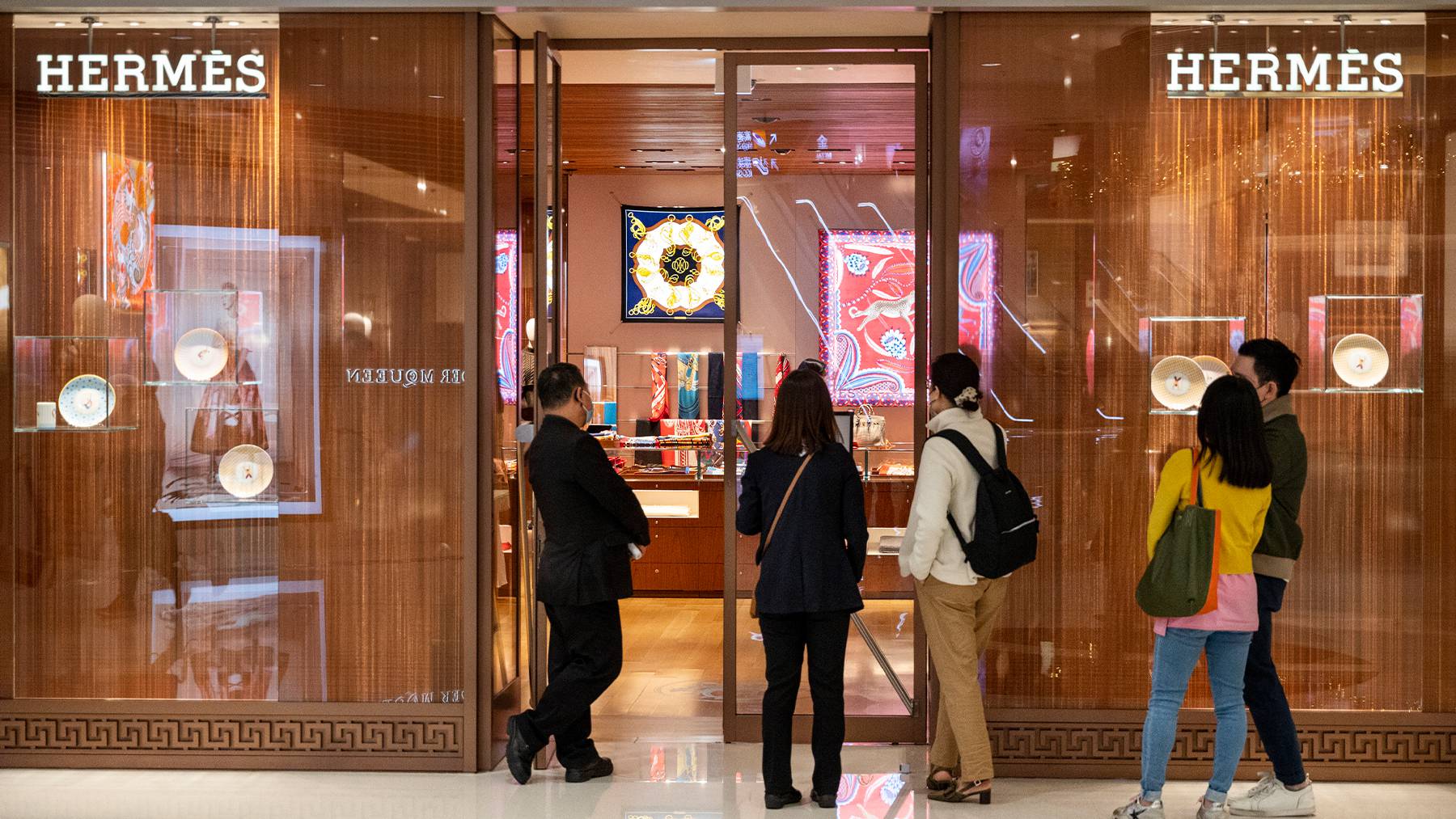 Shoppers queue to enter the French high fashion luxury clothing manufacturer Hermès store in Hong Kong.