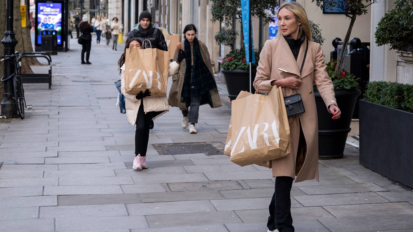 A woman and a child carry Zara shopping bags along Brompton Road in Knightsbridge, London.