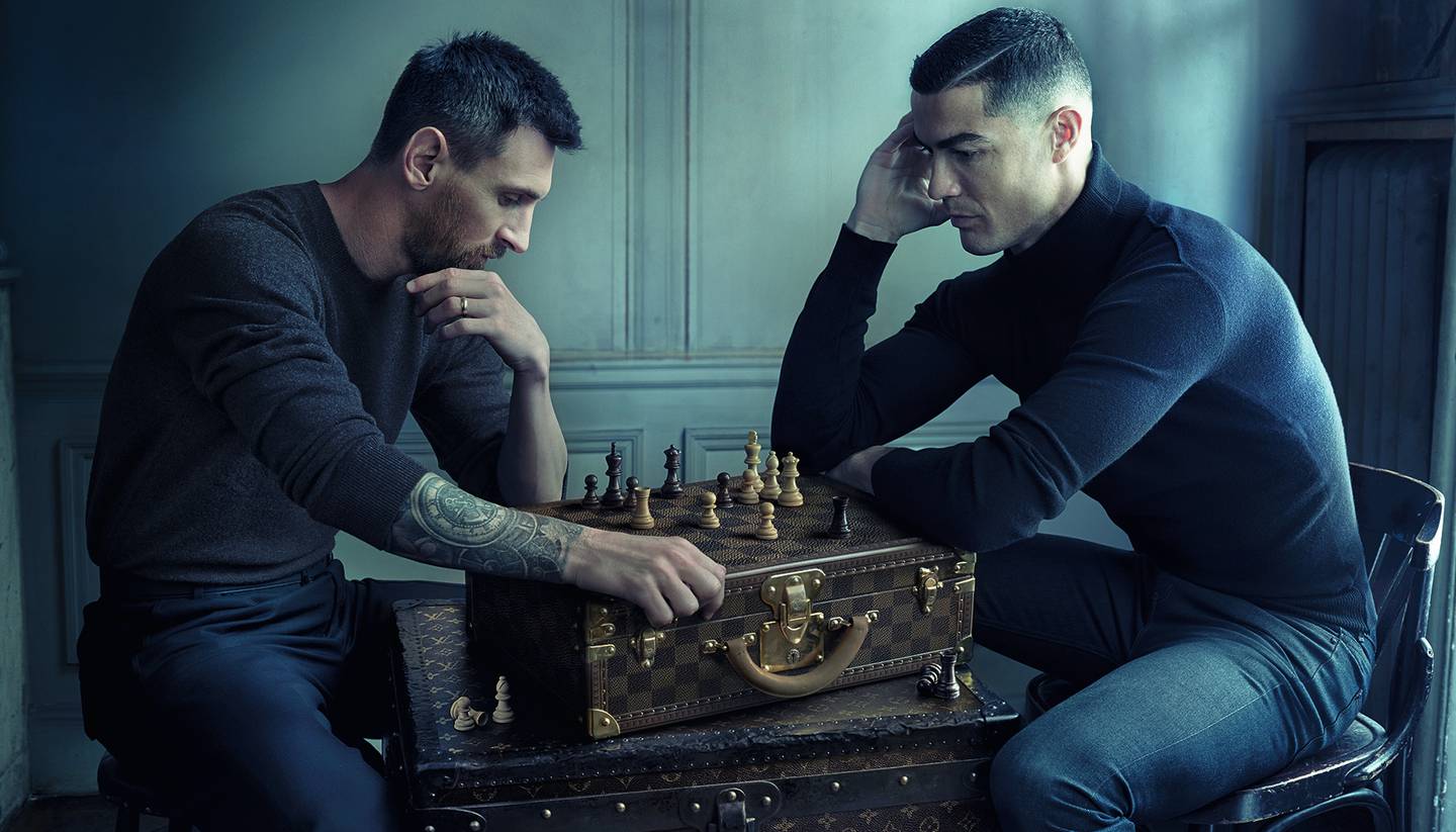 Football superstars and longtime rivals Lionel Messi and Cristiano Ronaldo play chess on a Louis Vuitton trunk in a campaign shot by Annie Leibovitz.