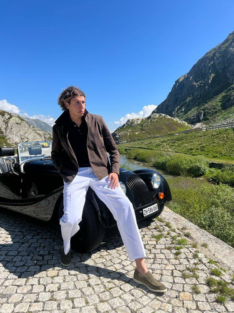 Gstaad Guy posing in front of a luxury car.