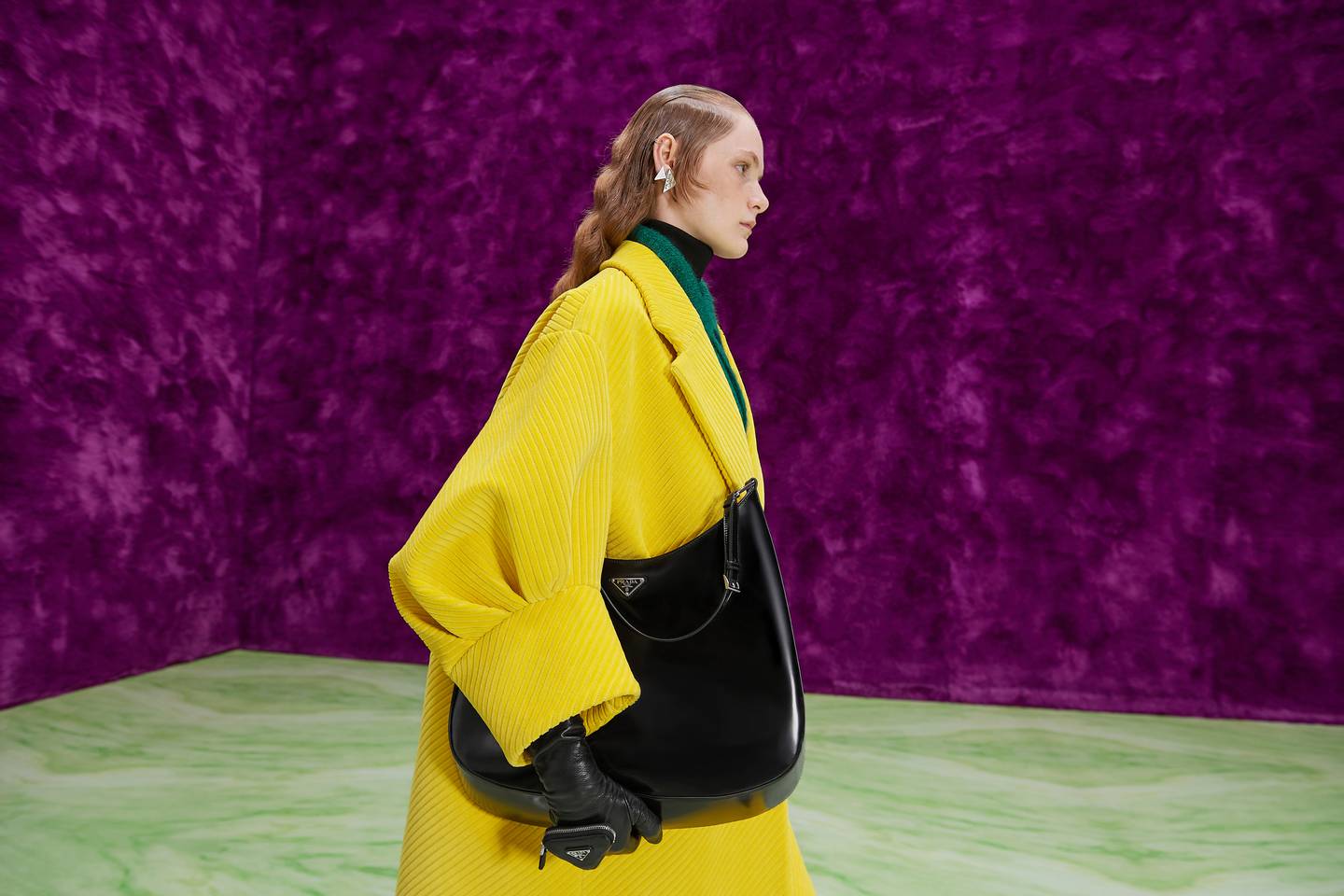A model carries Prada's Cleo bag in Miuccia Prada and Raf Simons' Fall/Winter 2021 show.
