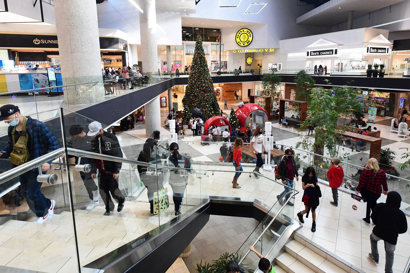 People walk at a shopping mall in Santa Anita, California on December 20, 2021.