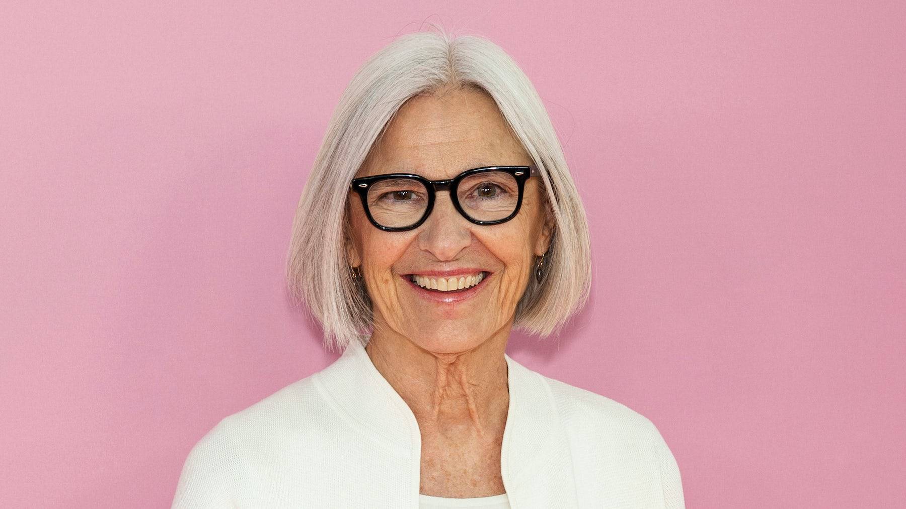 Eileen Fisher standing in front of a pink background.
