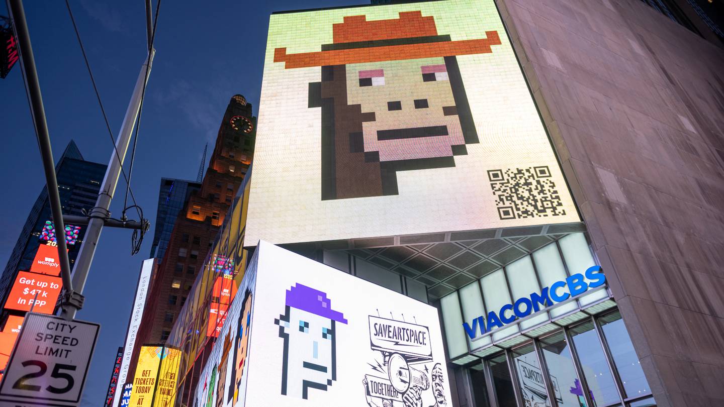 Billboards in New York City show two CryptoPunks NFTs, including one of an ape wearing an orange hat.