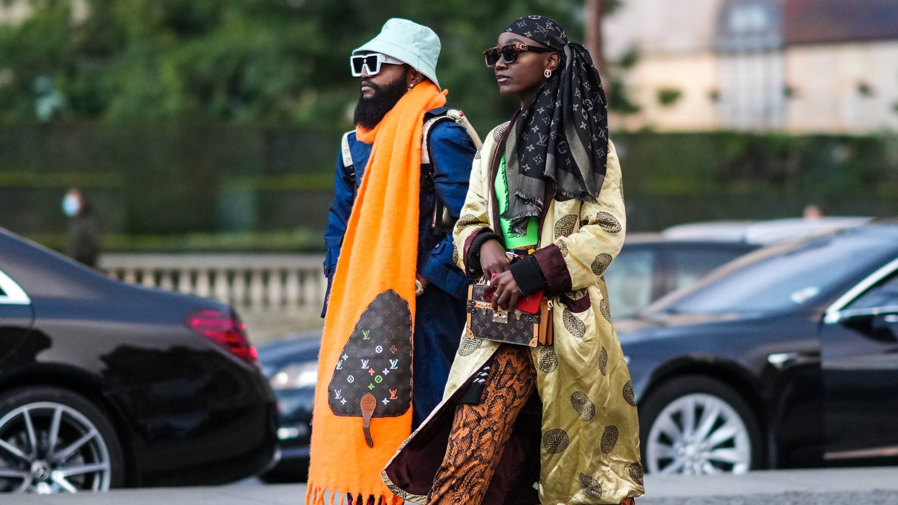Two Black guests wearing Louis Vuitton outside the Louis Vuitton Paris Fashion Week Show.