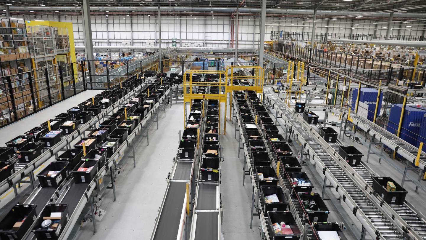 A wide shot of a fulfillment centre with lots of conveyor belts and machinery.