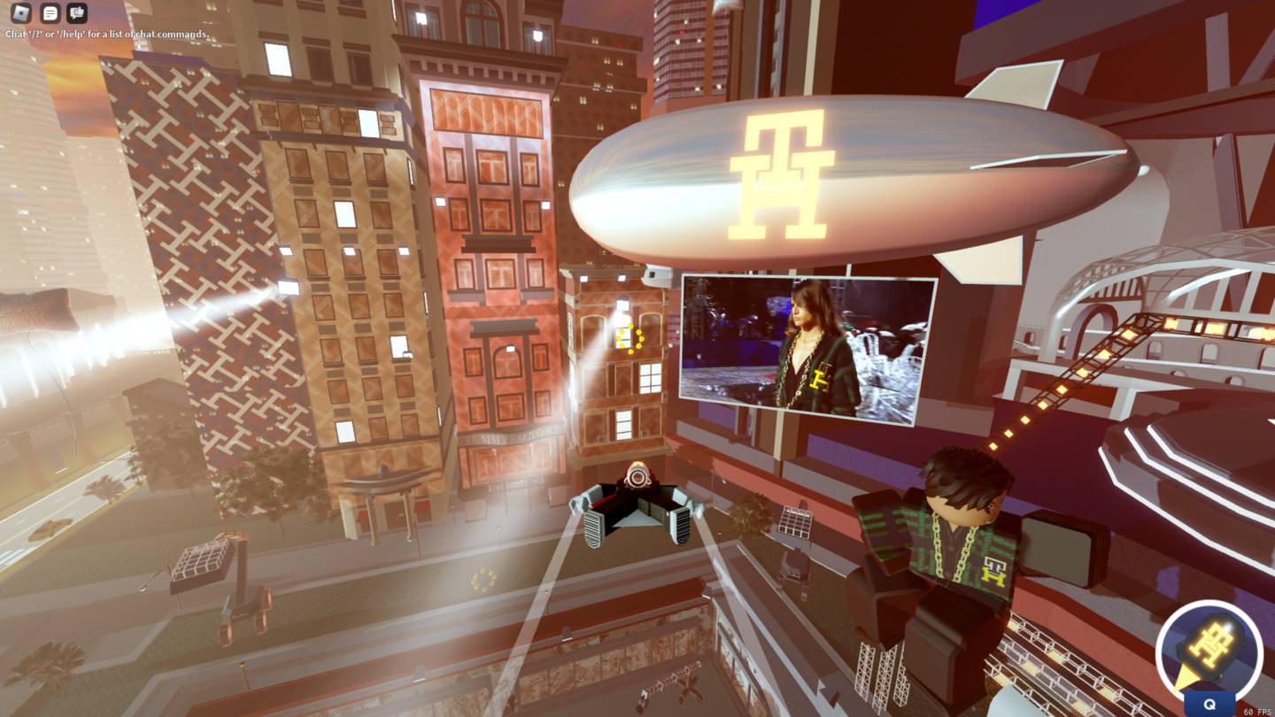 An avatar in a wing suit flies toward a large screen showing Tommy Hilfiger's runway show amid the backdrop of a virtual version of New York.