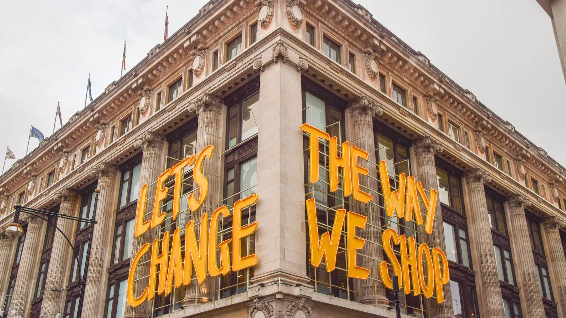 Selfridges' store front on London's Oxford Street is covered in bright yellow letters spelling the words "Let's Change The Way We Shop."