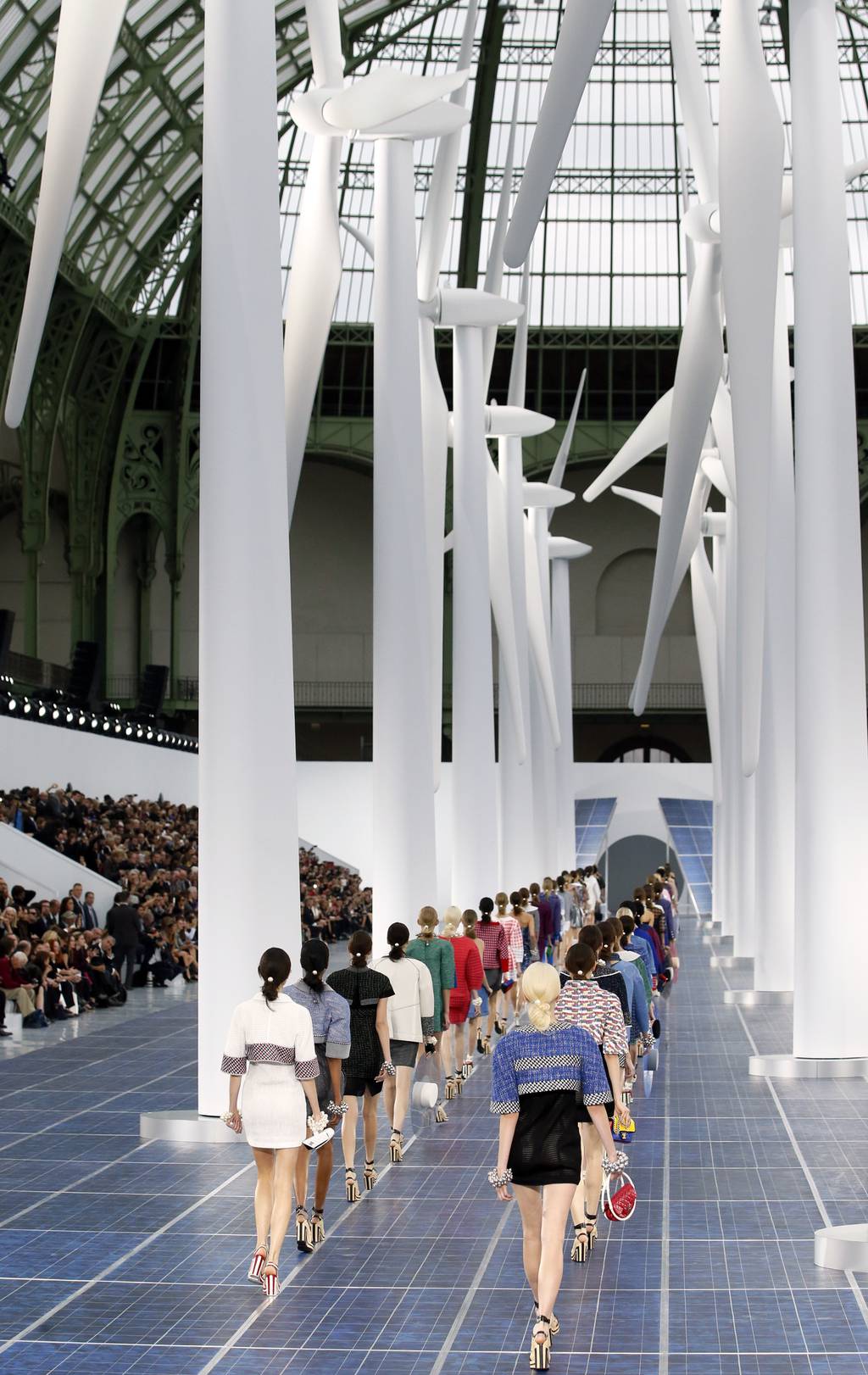 Models walk a Chanel catwalk paved with solar panels and framed by wind turbines.