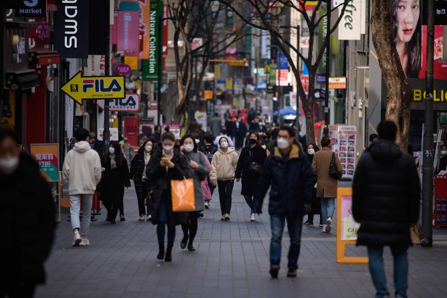 Pedestrians wearing face masks walk through Seoul's Myeongdong shopping district. Getty Images.