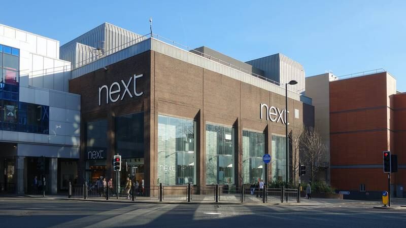 Next Cuts Profit Forecast as Shoppers Feel the Squeeze