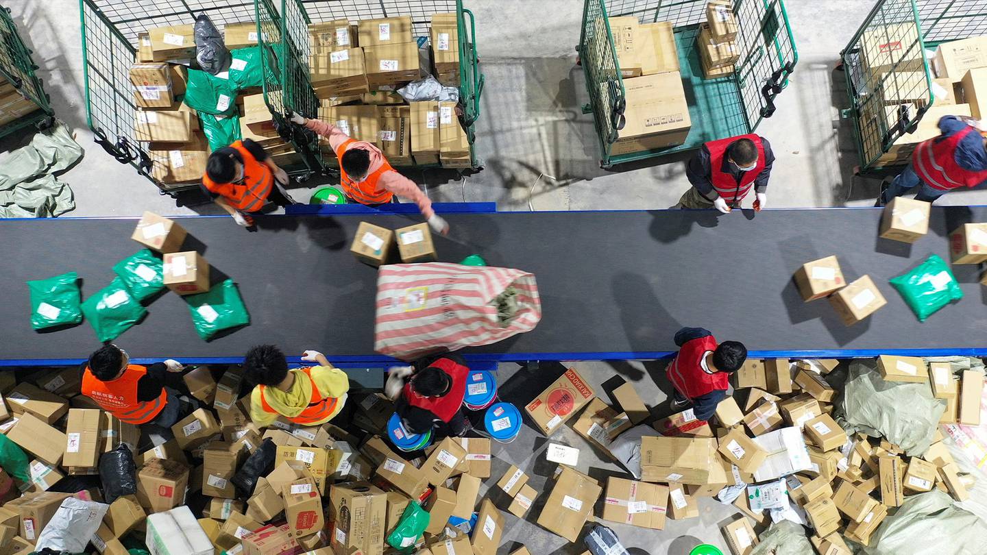 Workers sort packages for delivery at a warehouse of China Post Group in Hengyang, in central China's Hunan province. Getty Images.