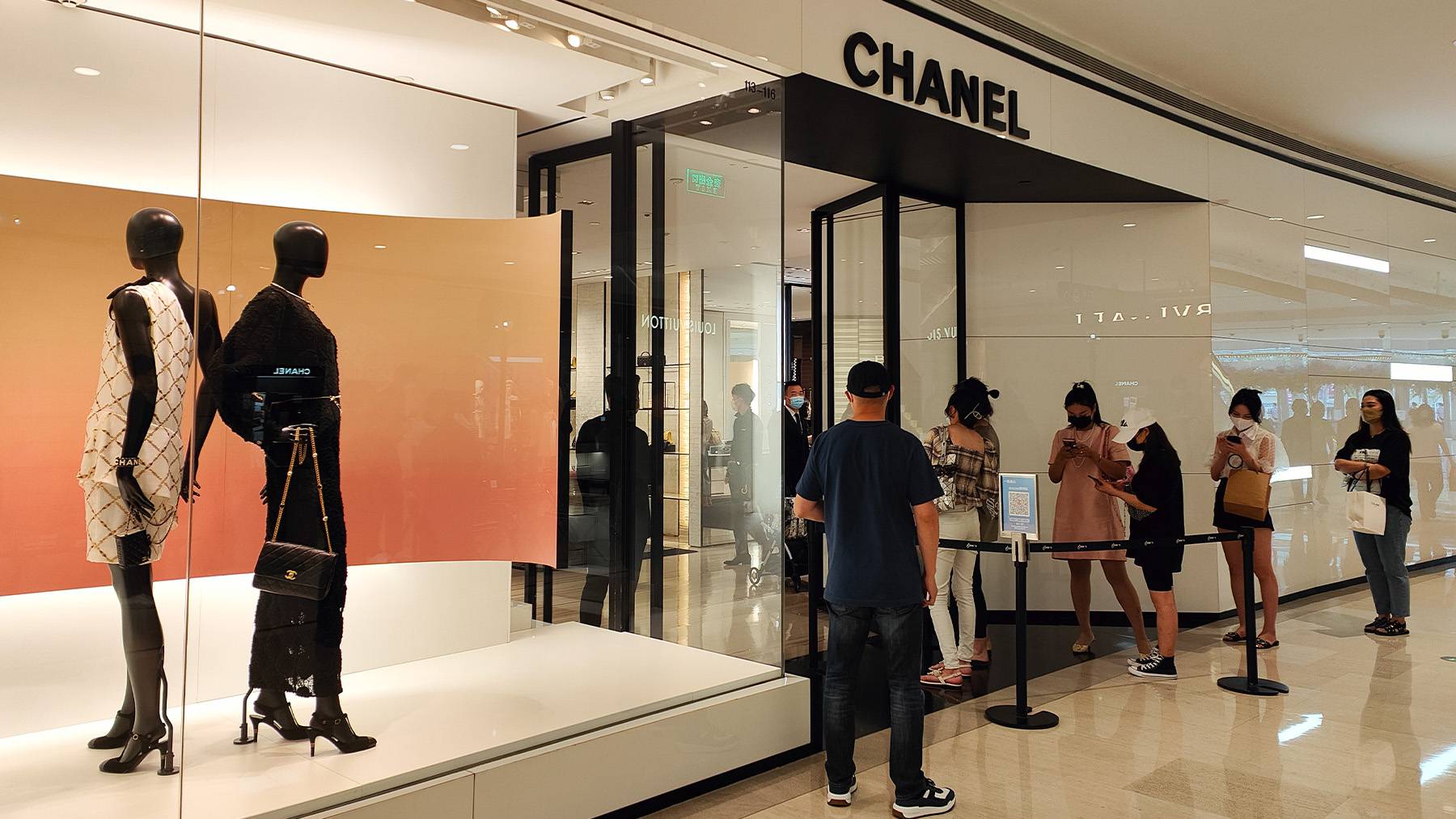 A Chanel store in Shanghai with customers queuing outside the store extrance.