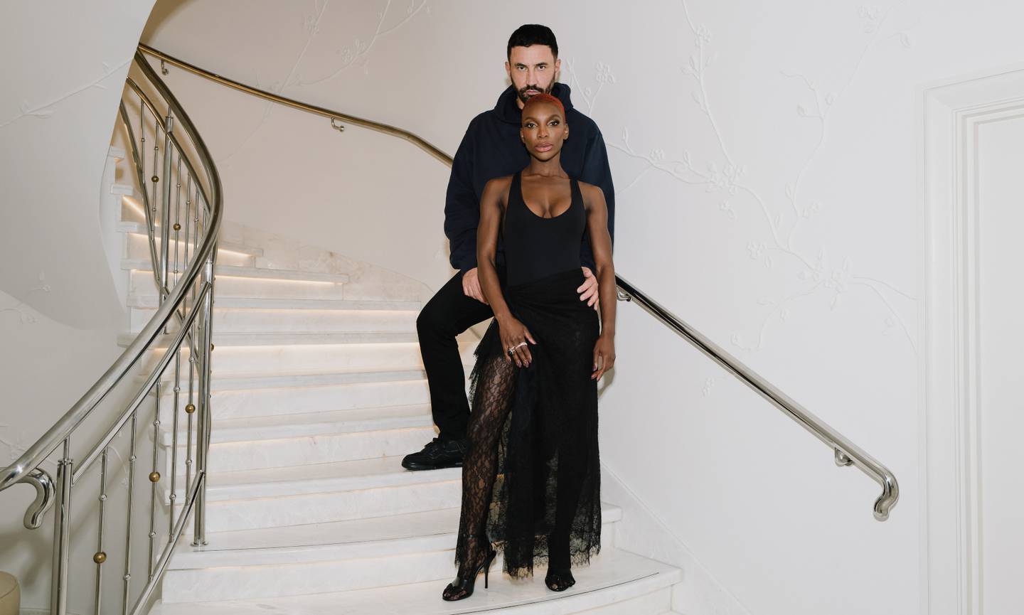Tisci and Coel pose on a set of winding white steps.