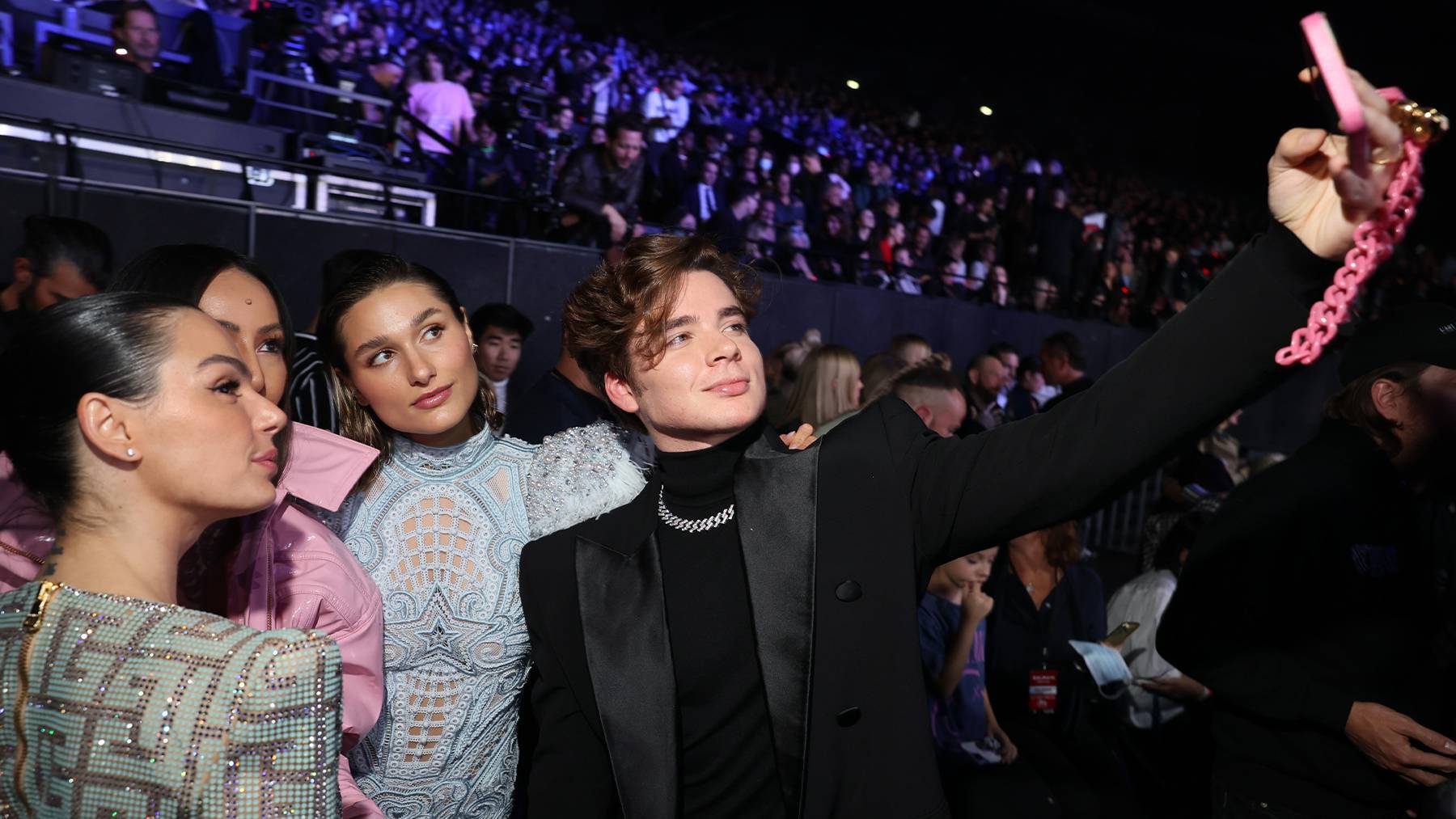 VIP guests including model Sasha Meneghel and singer João Figueiredo pose for a selfie at Balmain's festival during Paris Fashion Week. Getty Images.