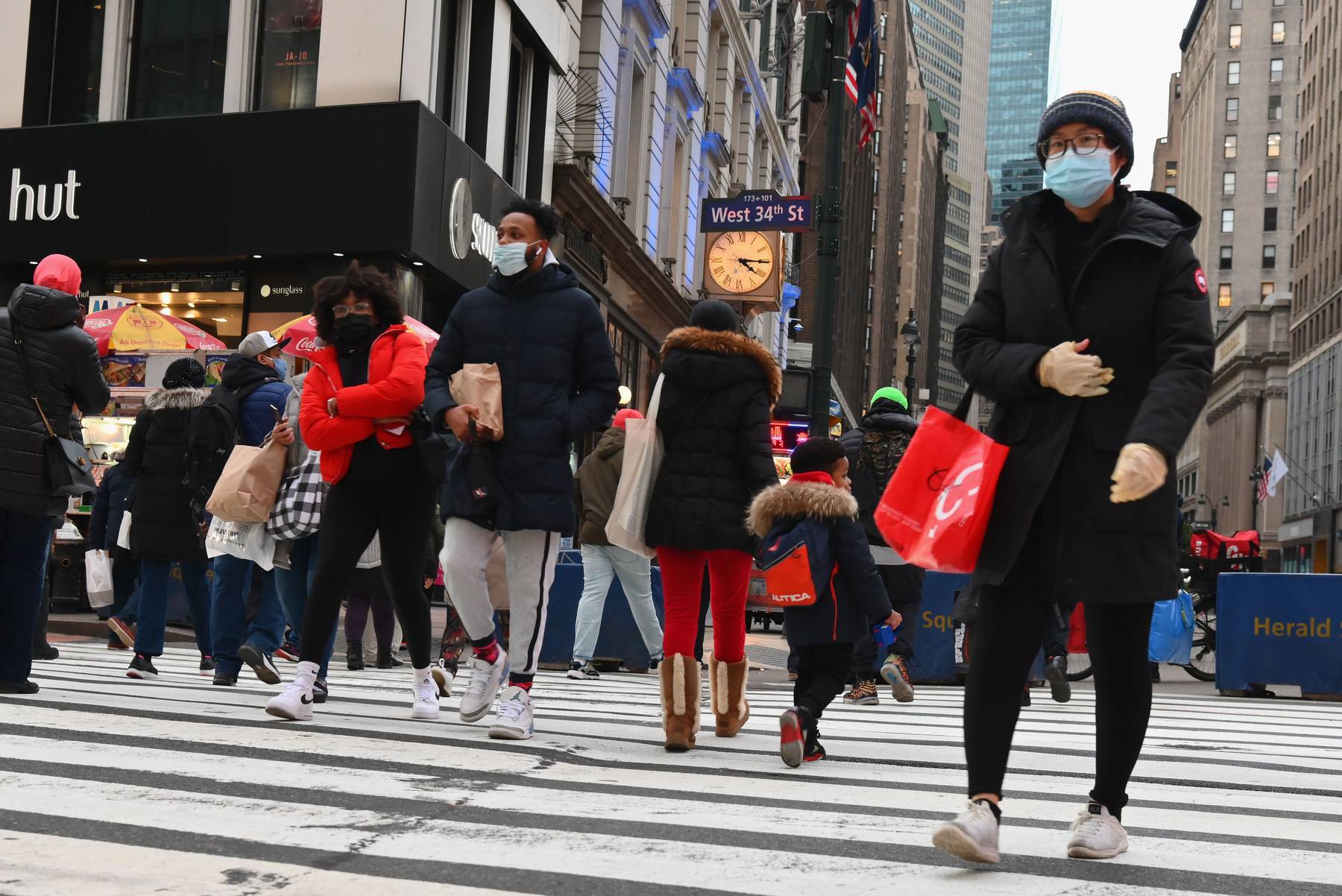 People wear face masks as they walk through Herald Square in New York City in January 2021. Getty Images.