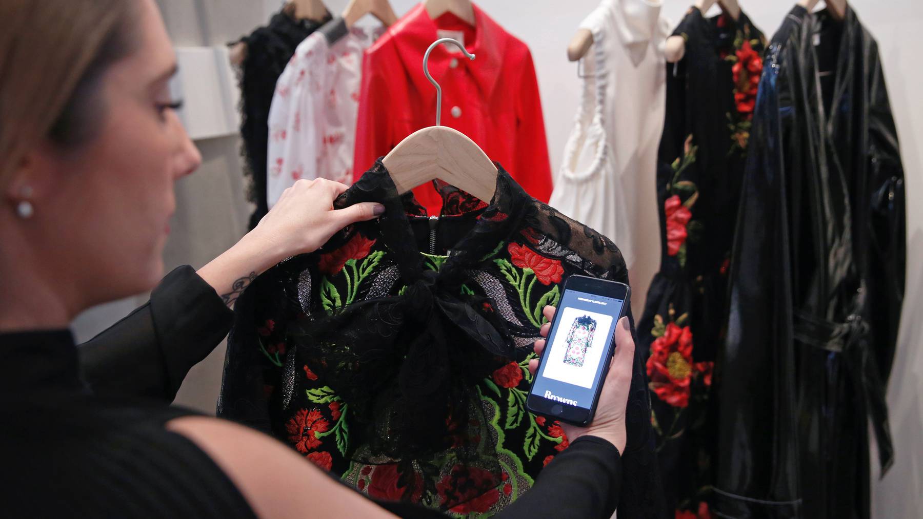 A Farfetch employee uses an app linked to store products at the launch of the "Store of the Future" exhibition at the Design Museum in London