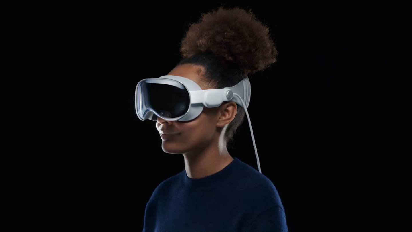 A woman wears Apple's new augmented-reality headset, which looks like a pair of ski goggles.