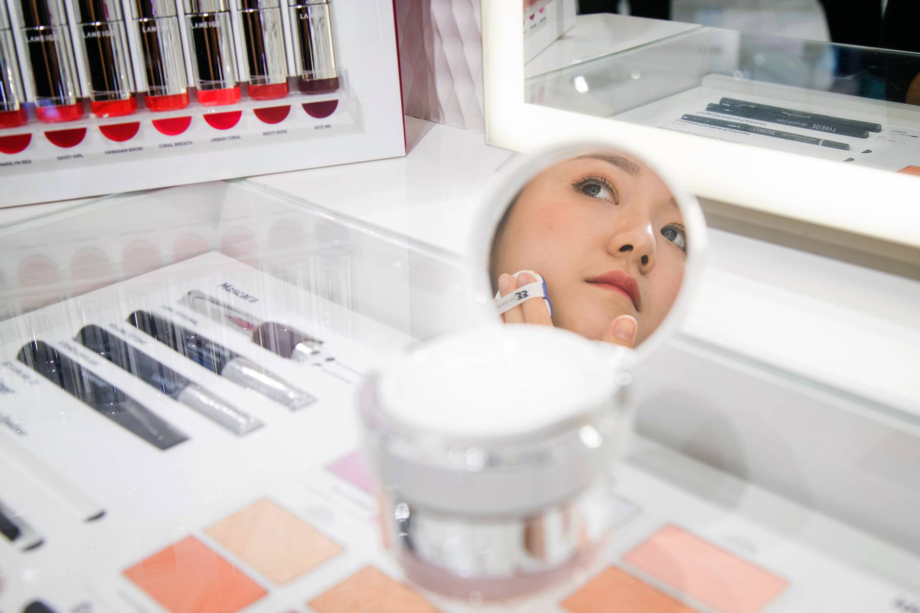 A store employee applying foundation in a Laneige boutique, which is an Amorepacific brand.