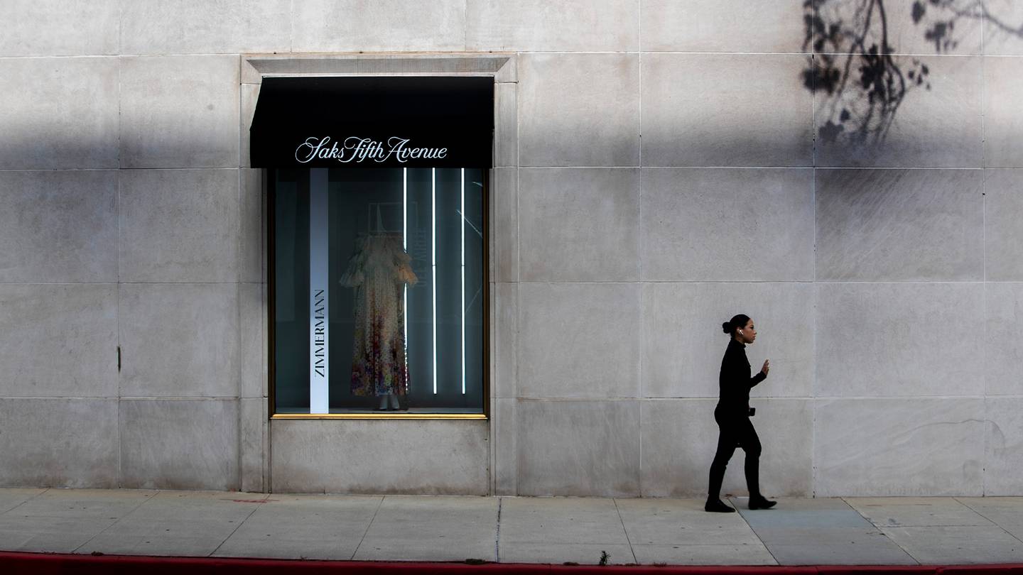 Saks store exterior with a person walking past the shop front.