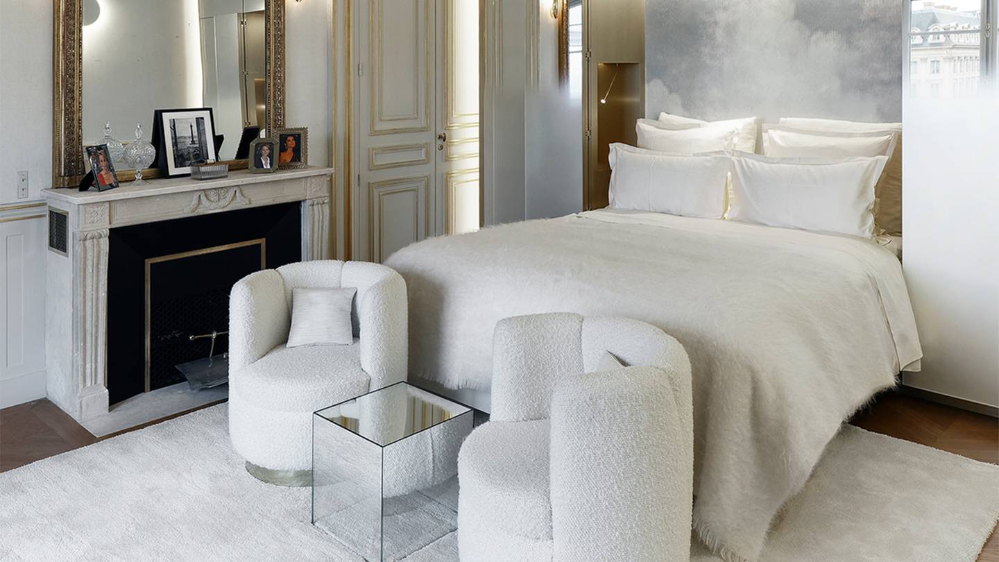Bedroom in Boucheron luxury apartment, complete with a fireplace, two loveseats, and a bed.