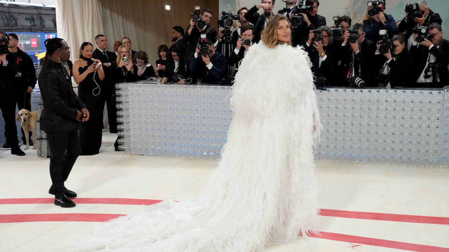 Gisele Bündchen attends the Met Gala in a white feather cape.