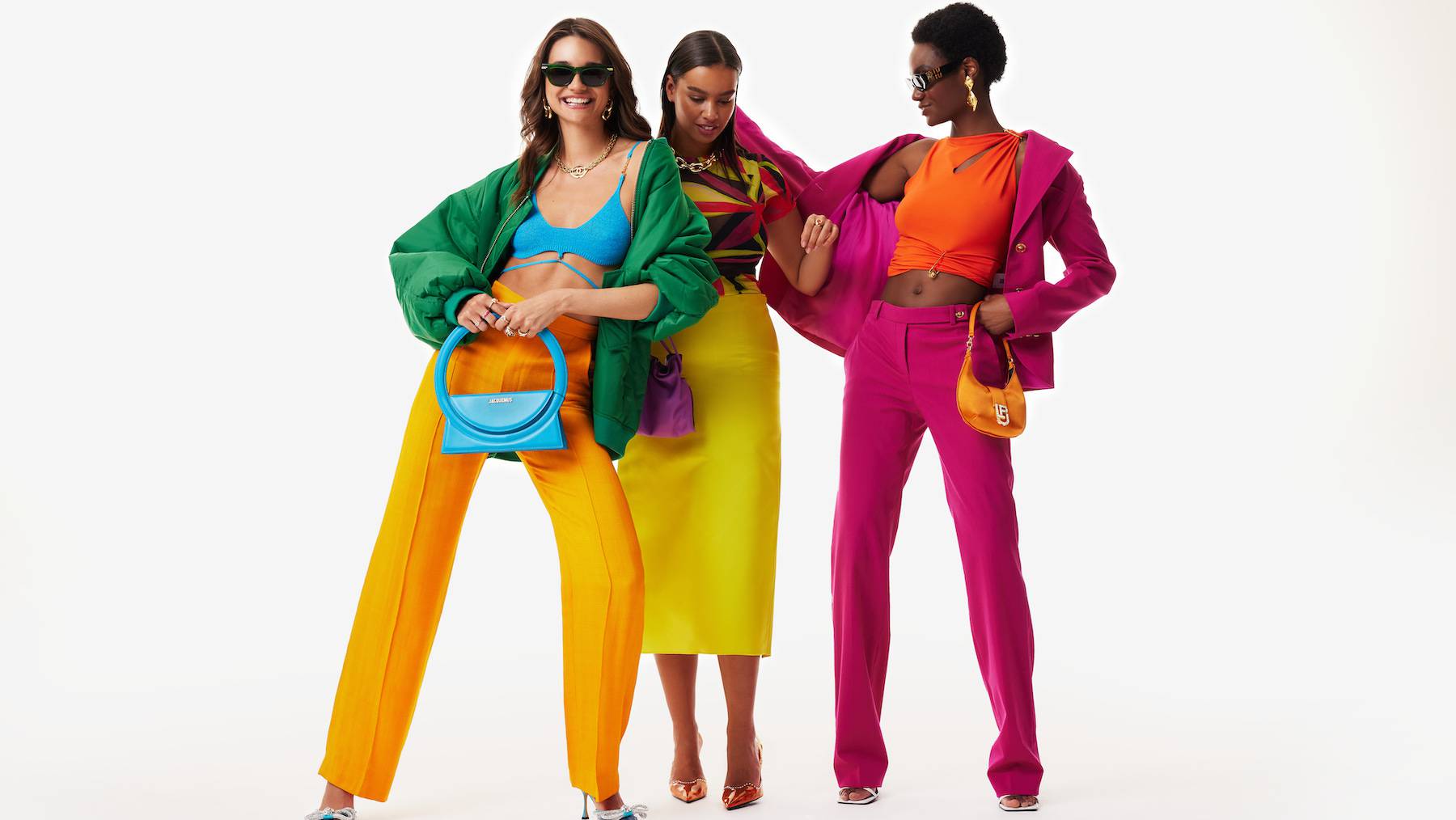Three women modelling a colourful assortment of clothes and accessories.