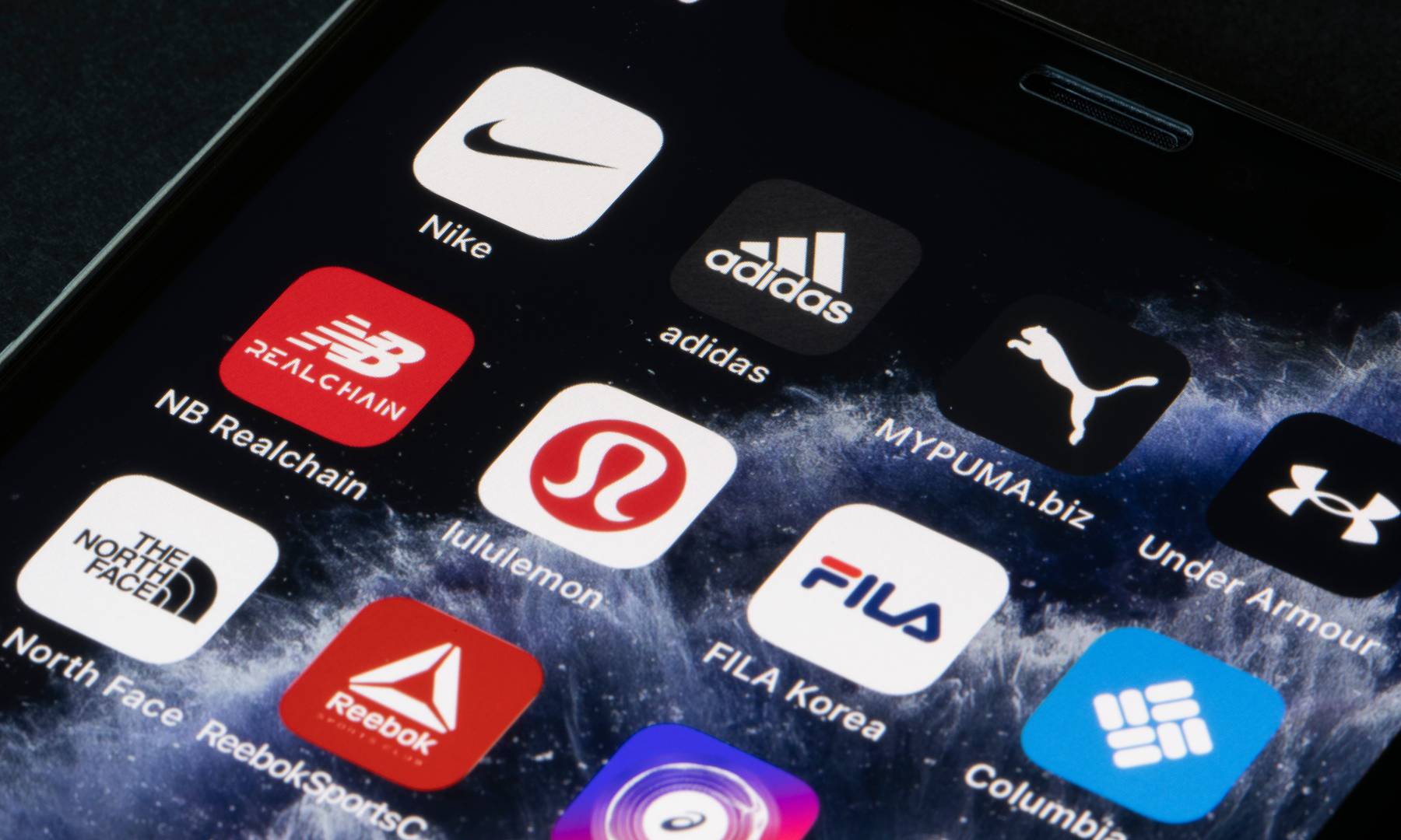 An array of apps from different activewear companies are displayed on a phone screen.