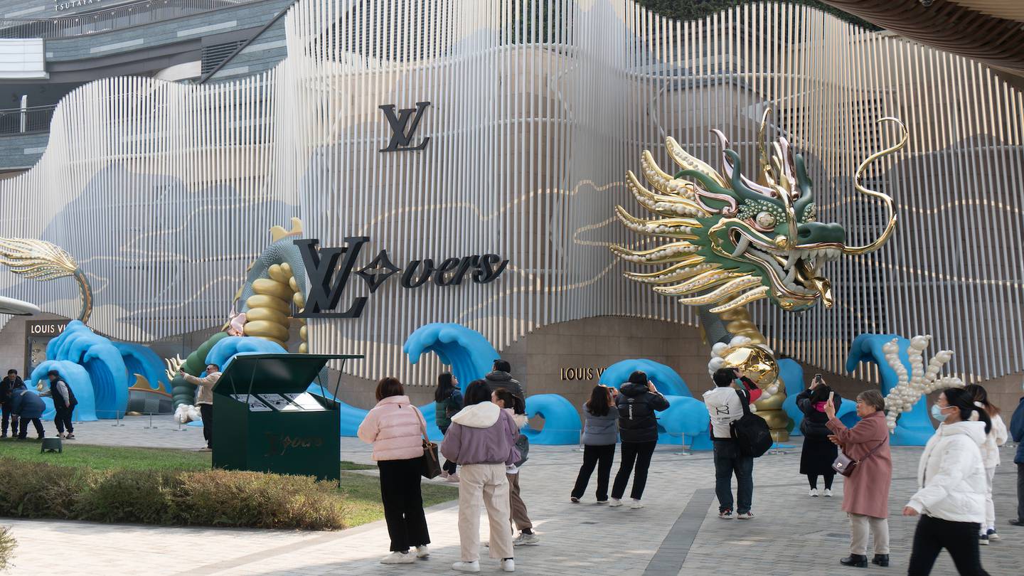 Visitors look at a gold, green and jade dragon sculpture created by luxury brand Louis Vuitton in Shanghai, China, Jan. 2, 2024.