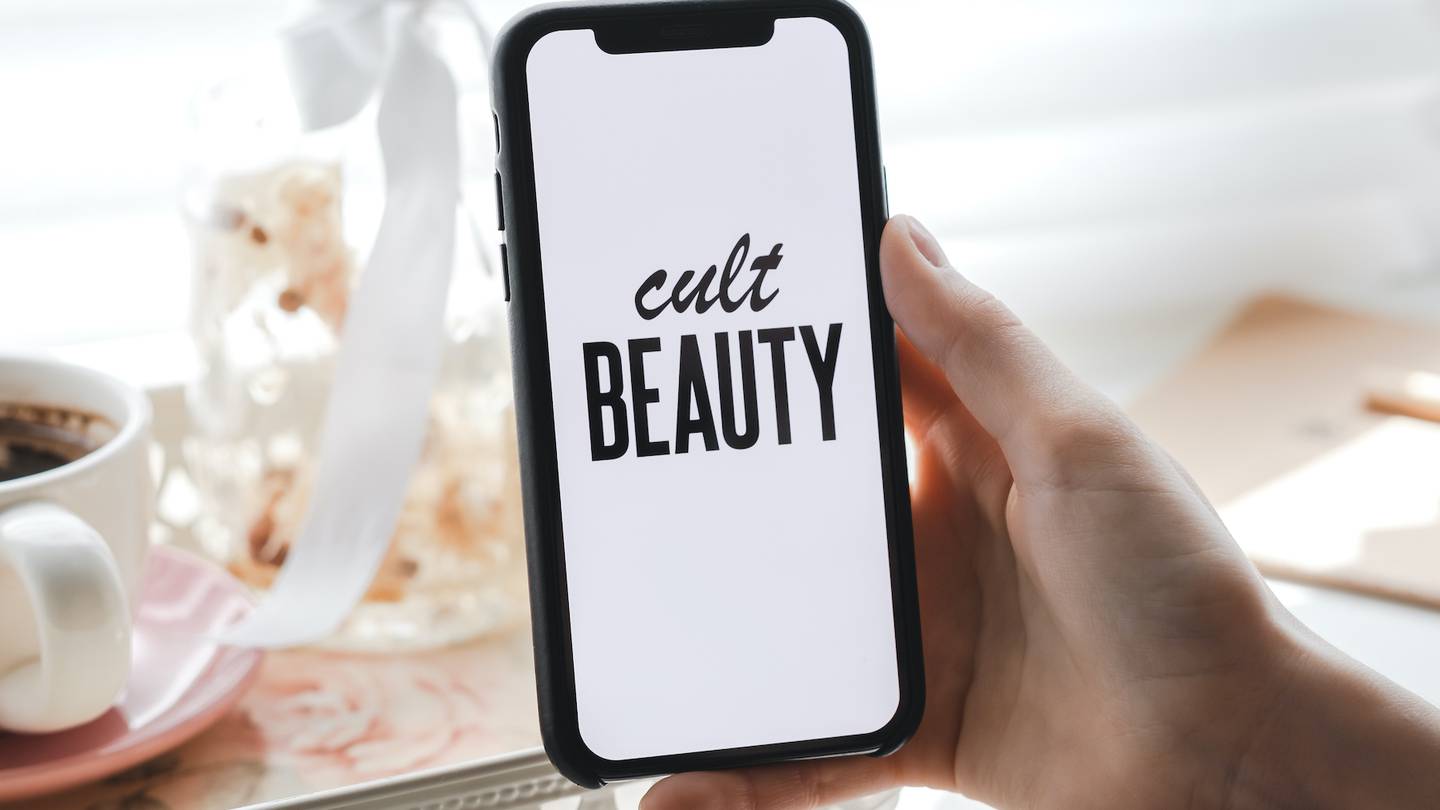 Cult Beauty shop logo on the iPhone screen.